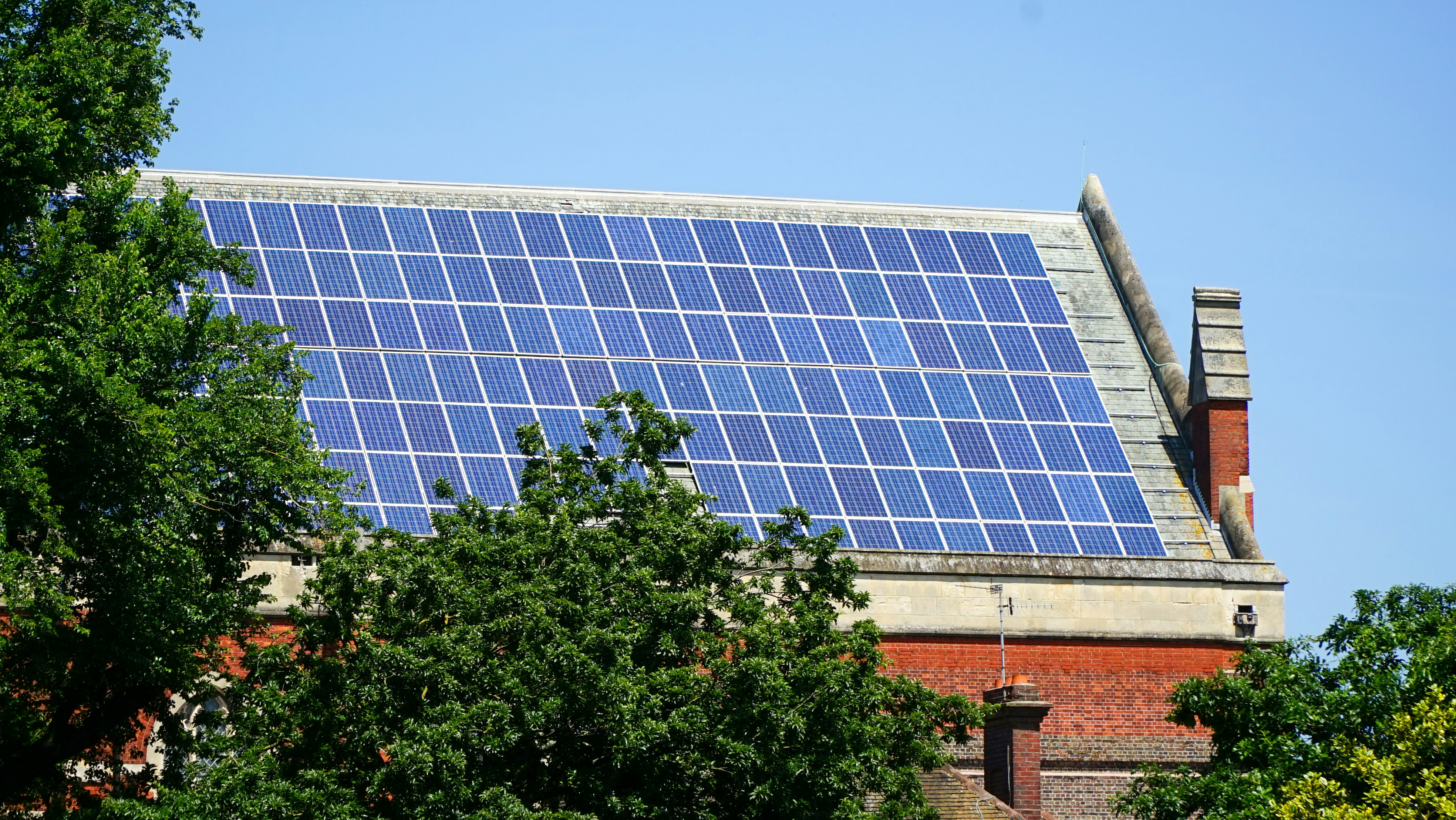 Solar panels covering a rooftop beneath a clear blue sky